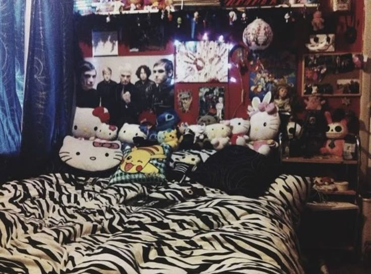 a bed with zebra print sheets and stuffed animals on the headboard in a bedroom