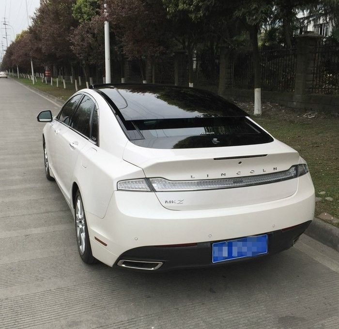 a white car is parked on the side of the road