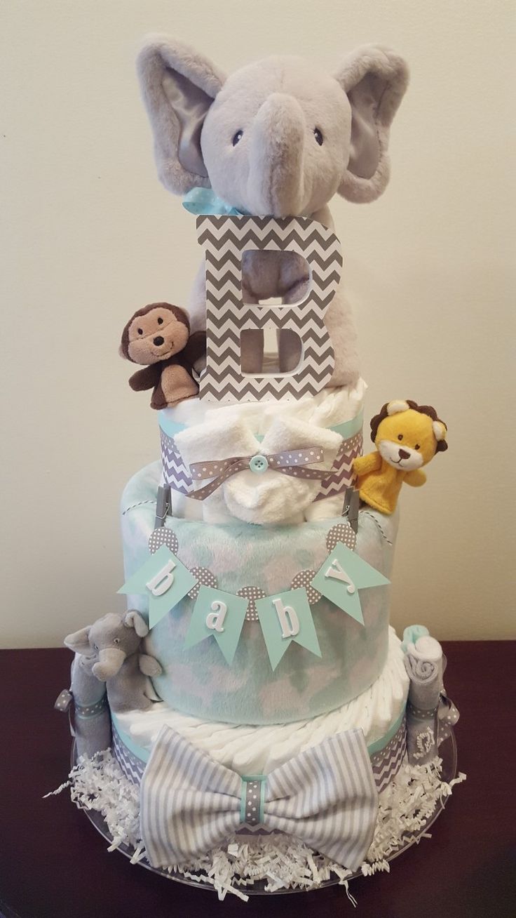 a diaper cake with an elephant, monkey and giraffe on top