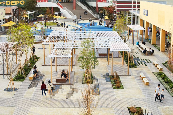 an aerial view of people walking and sitting in the courtyard area of a shopping center