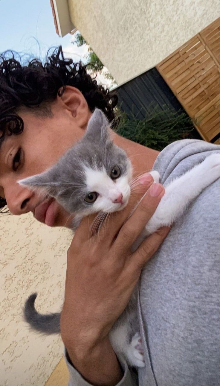 a man holding a cat up to his face