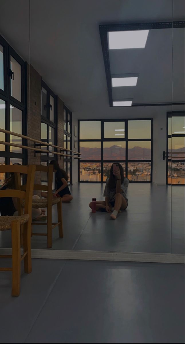 two women sitting on the floor in front of large windows