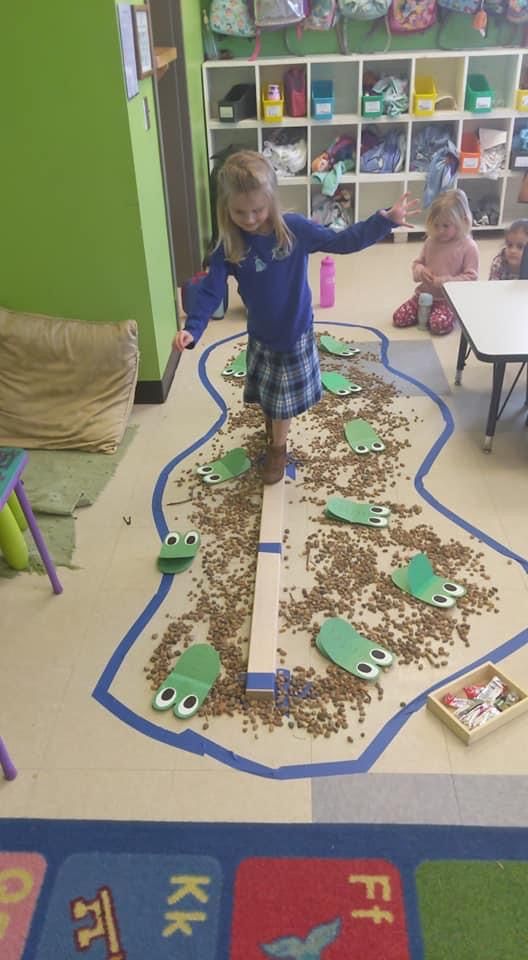 two children playing in a playroom with lots of toys on the floor and rugs