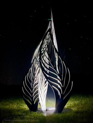 an artistic sculpture in the grass at night