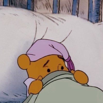 winnie the pooh sleeping in bed wearing a pink hat