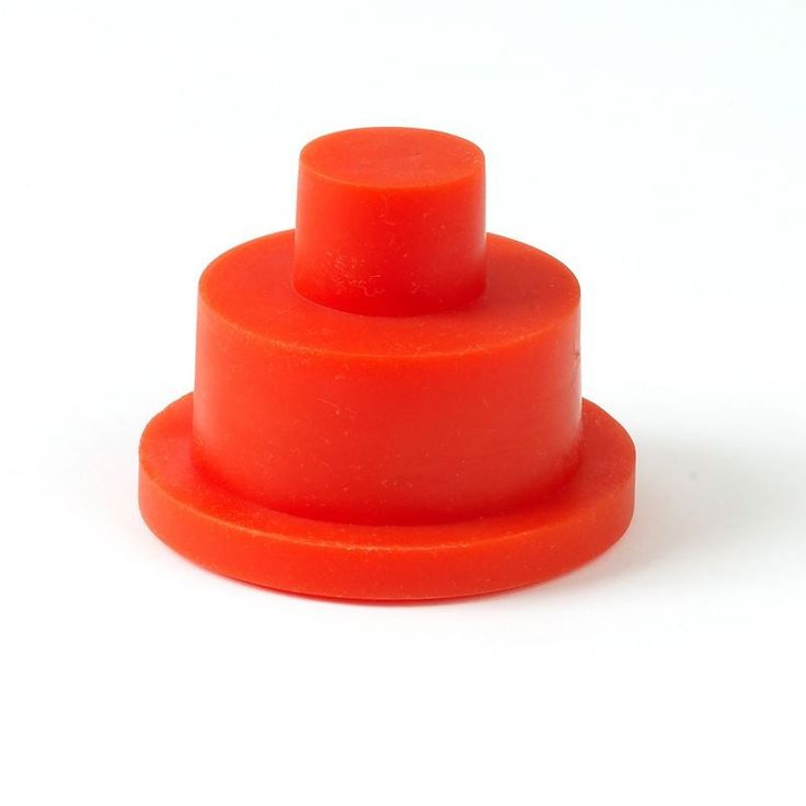 an orange plastic object is on a white surface and it appears to be stacked up