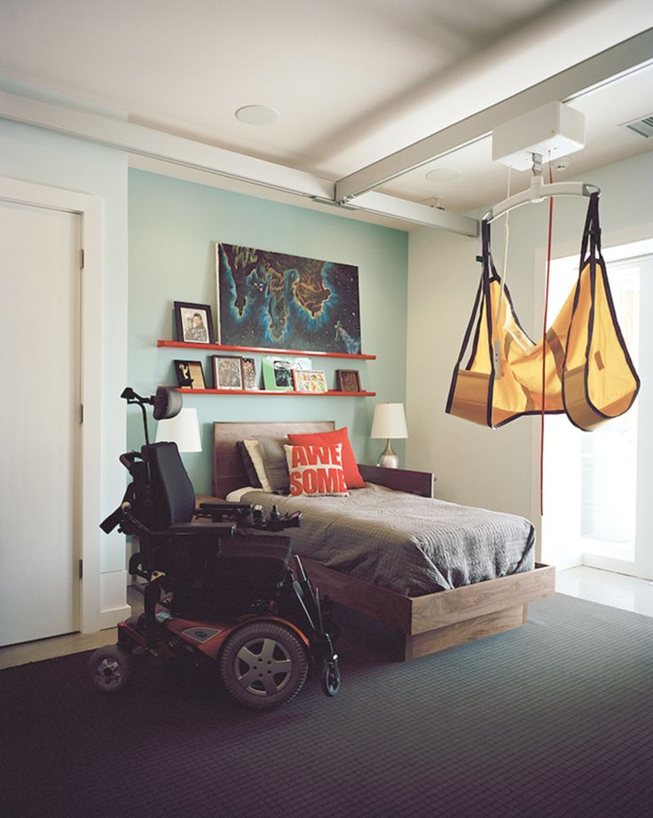 a bedroom with a bed, chair and hanging lights in it's center area