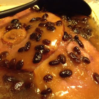 a pan filled with food covered in raisins on top of a stovetop