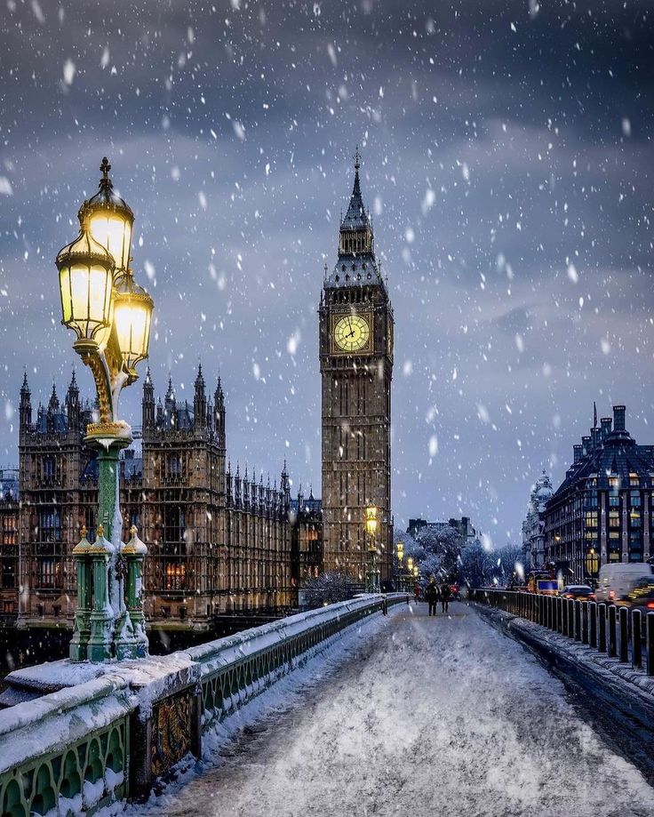 the big ben clock tower towering over the city of london during a snow storm at night