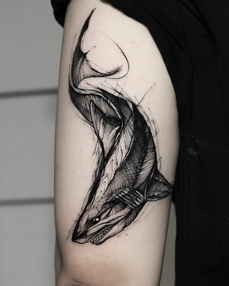 a woman's arm with a black and white drawing of a fish on it