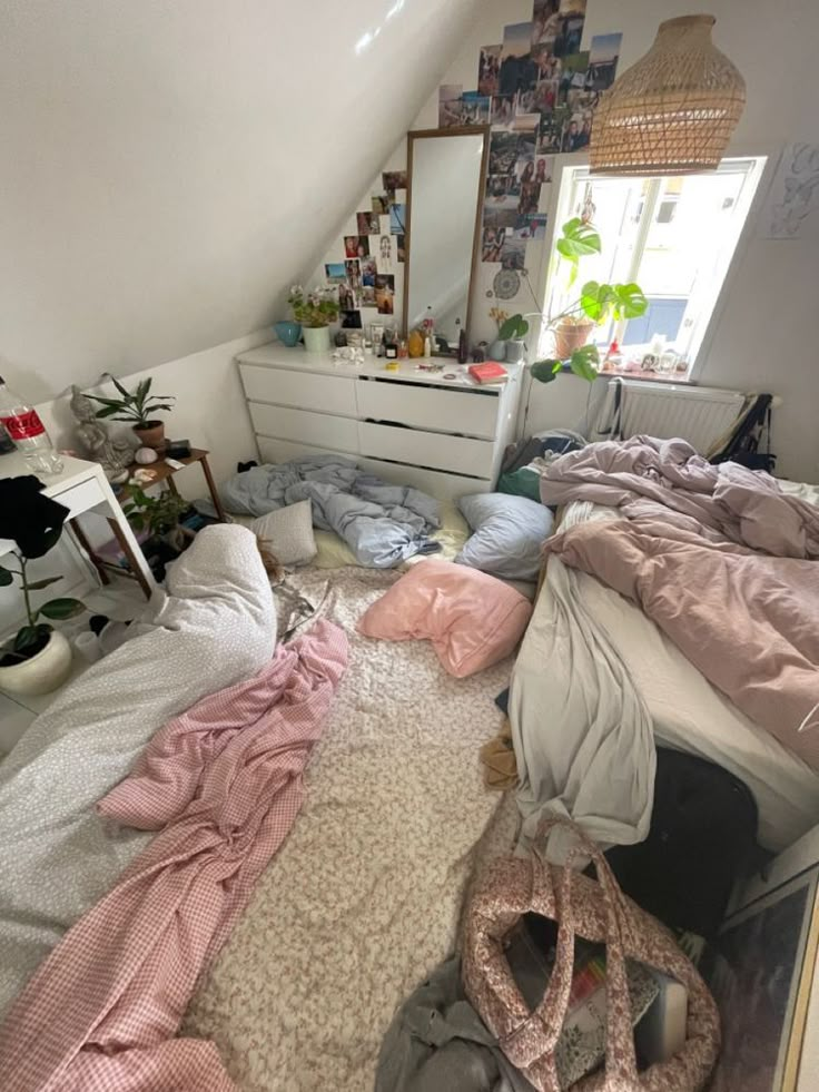 an unmade bed in a room with lots of clutter on the floor