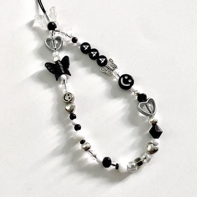 a black and white beaded bracelet with charms on it's end is shown