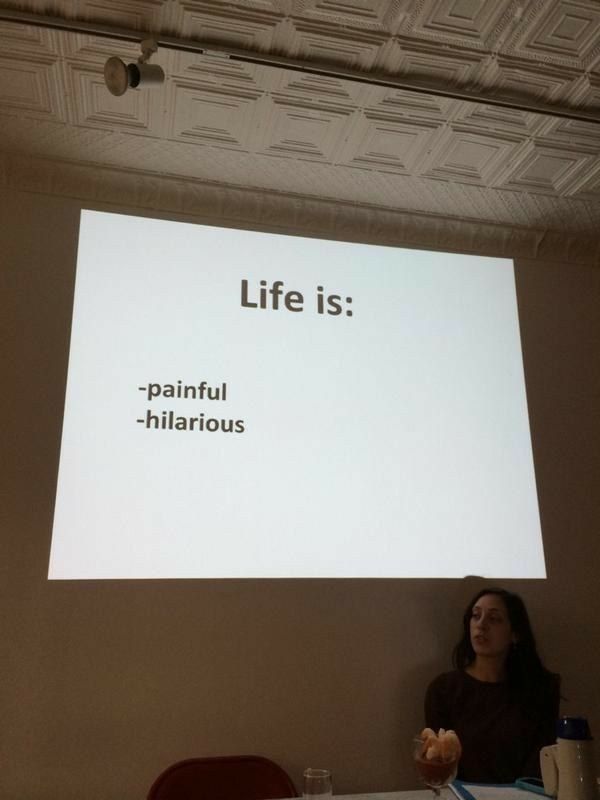 a woman standing in front of a projector screen giving a presentation on life is