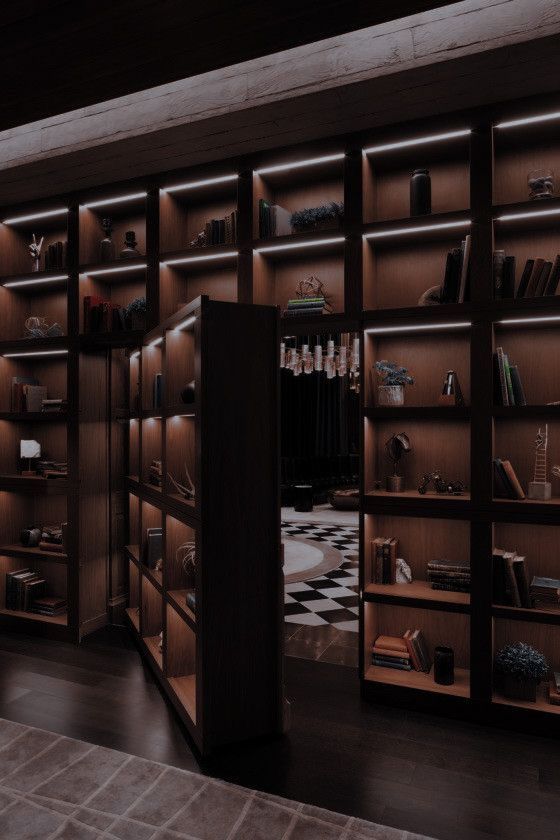 an open bookcase with many books on it in front of a black and white checkered floor