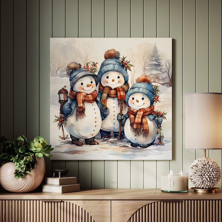 three snowmen standing next to each other in front of a painting on the wall