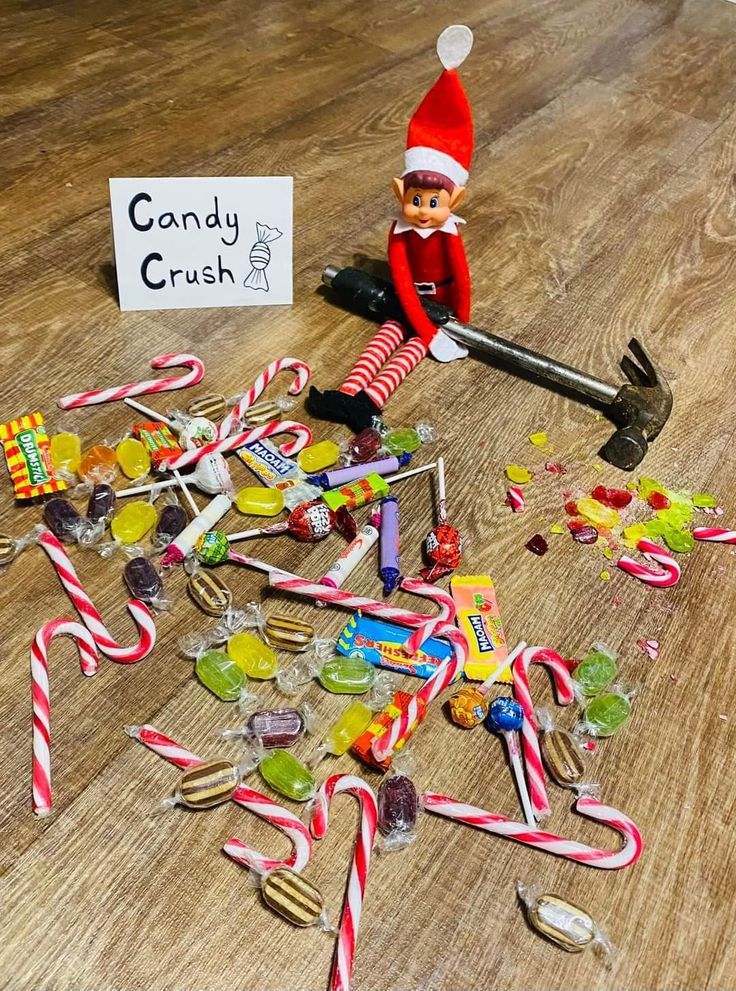 an elf with candy canes and candies on the floor next to a sign that says candy crush