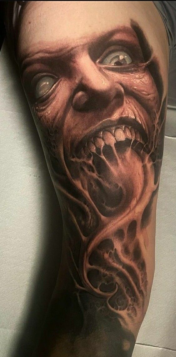 a man's leg with a tattoo on it that has a creepy face and mouth