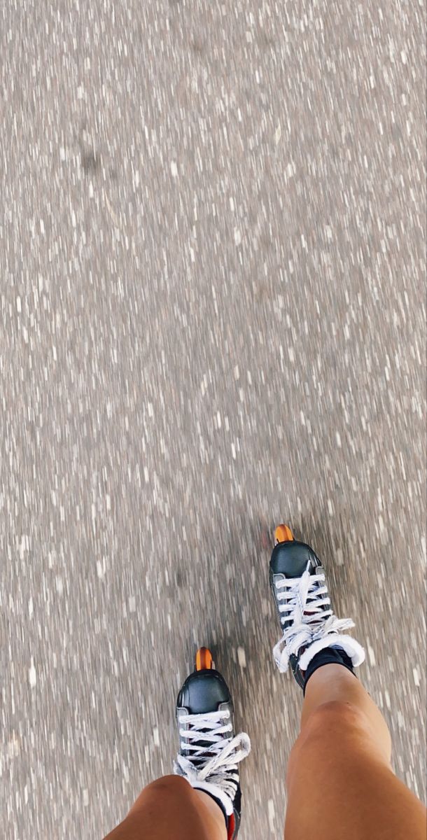 a person standing on the street with their feet up and wearing tennis shoes in front of them