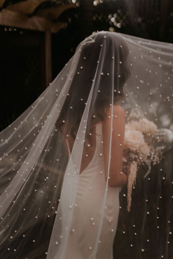 a woman wearing a veil and holding a bouquet