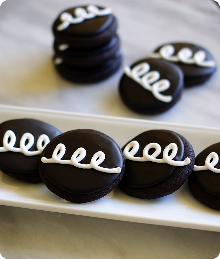 chocolate covered cookies with white icing are arranged on a plate that says eo