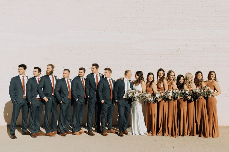 a group of people standing next to each other in front of a white brick wall