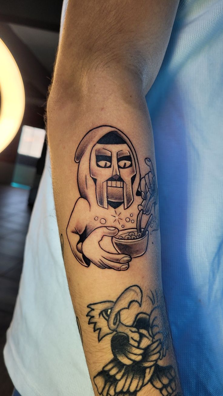 a man with a tattoo on his arm holding a bowl of food in front of him