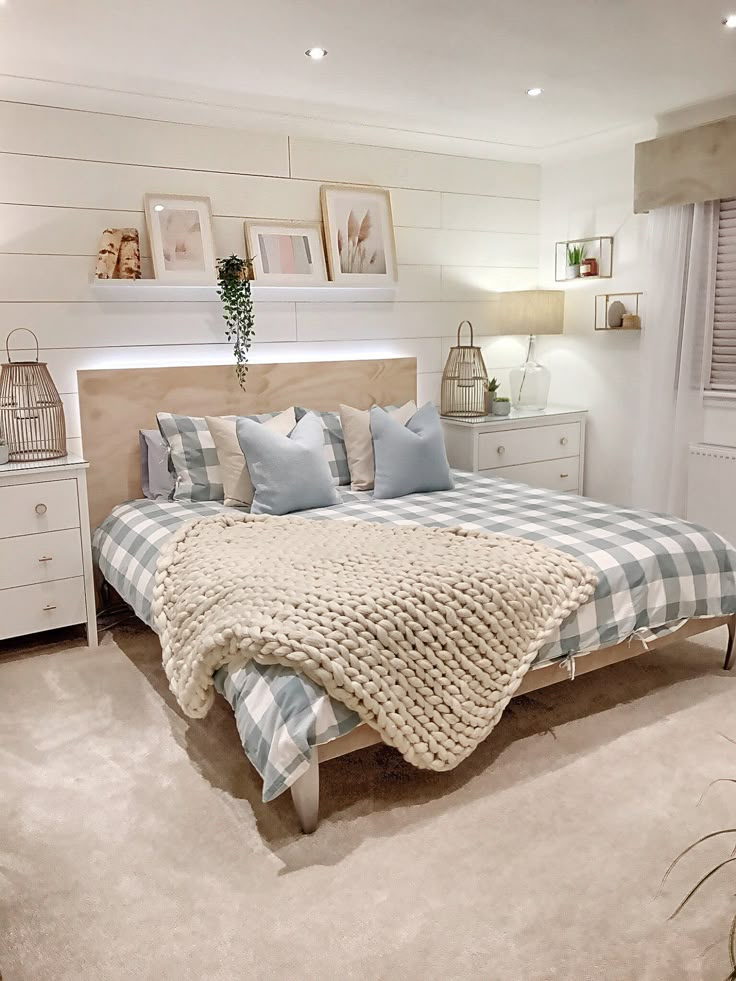 a bedroom with a bed, dressers and pictures on the wall