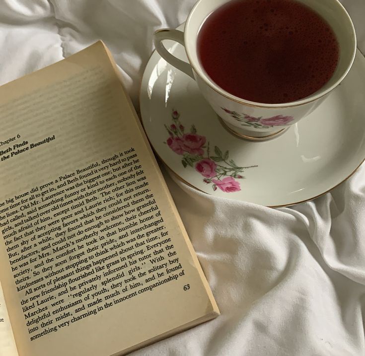 a cup of tea next to an open book