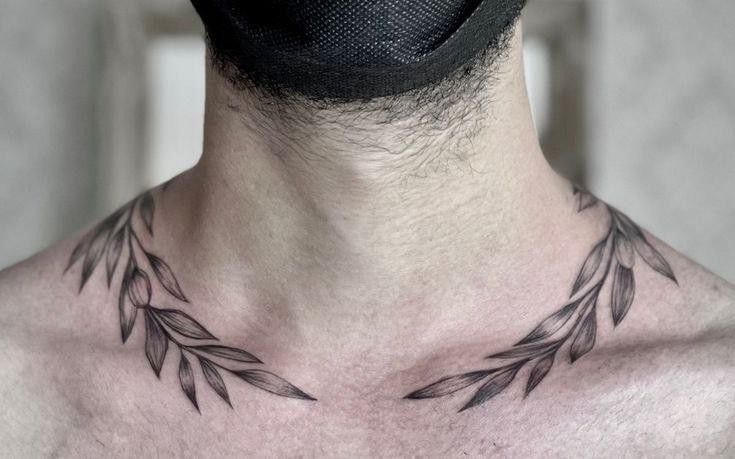 a man with a neck tattoo that has leaves on the back of his head and chest