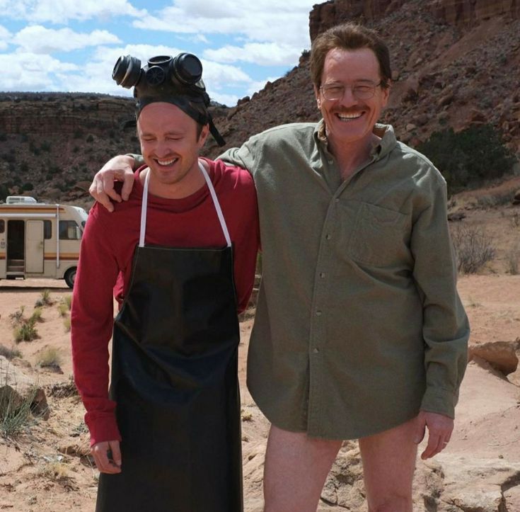 two men standing next to each other in the desert