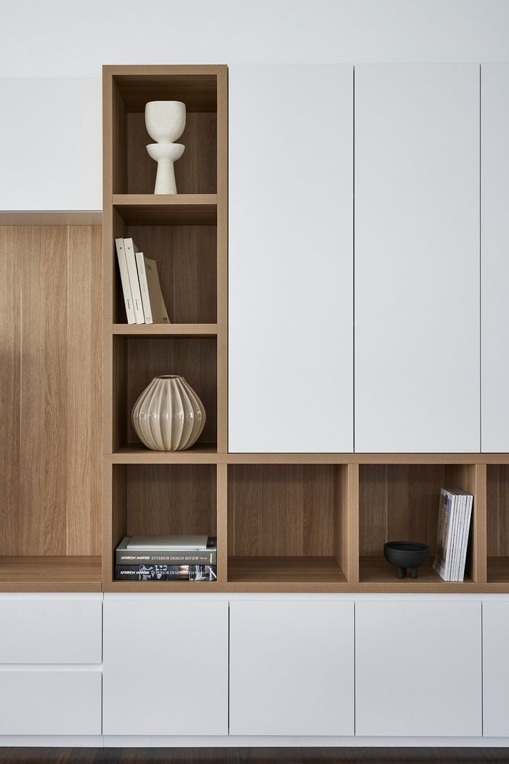 an empty shelf with books and vases on it