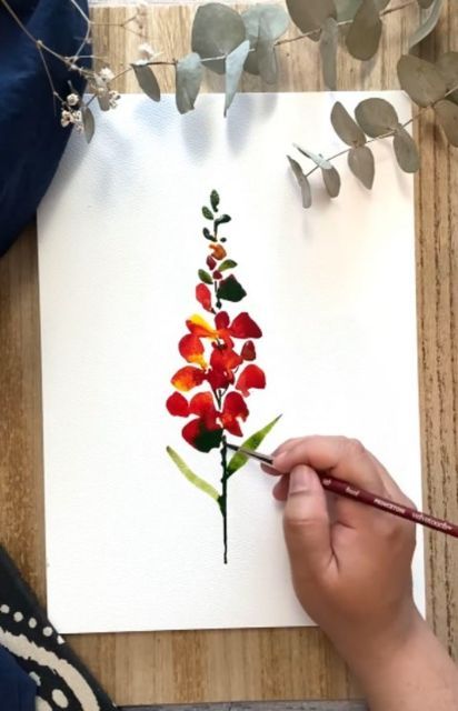 a person is painting flowers with watercolors on paper