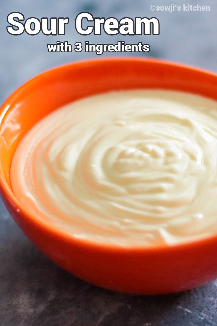 an orange bowl filled with cream on top of a table