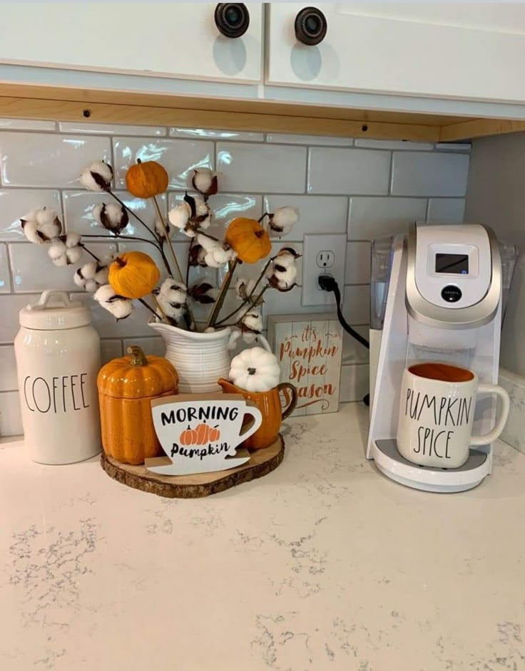 a coffee maker sitting on top of a kitchen counter next to a cup and mug