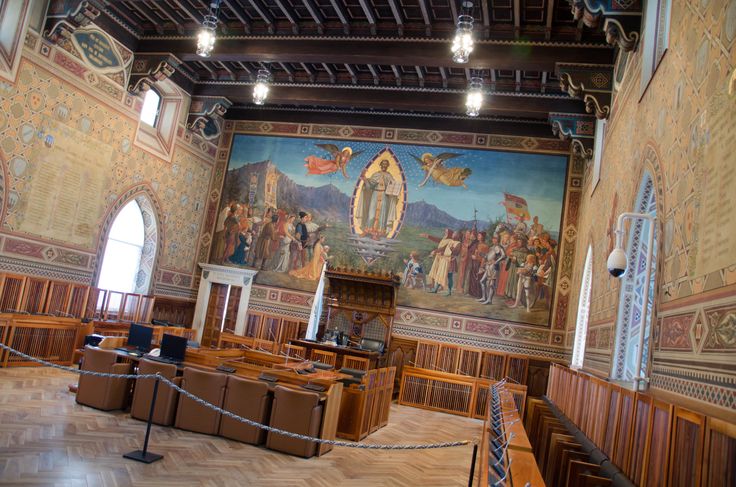 the inside of a large building with paintings on it's walls and wooden floors