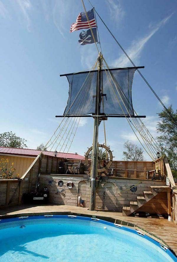 a pirate ship sitting on top of a wooden deck next to a swimming pool