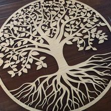 a wooden cutout of a tree with leaves and roots in the shape of a circle