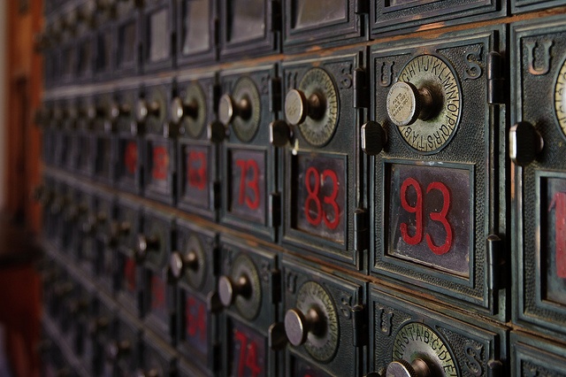 the numbers are written in red and black on an old metal mailbox that is being used as a wall decoration