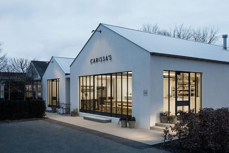 a white building with glass windows on the front and side of it that says canosa's