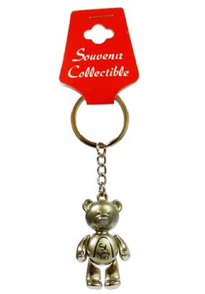 a metal key chain with a teddy bear on it's side and a red tag attached to it