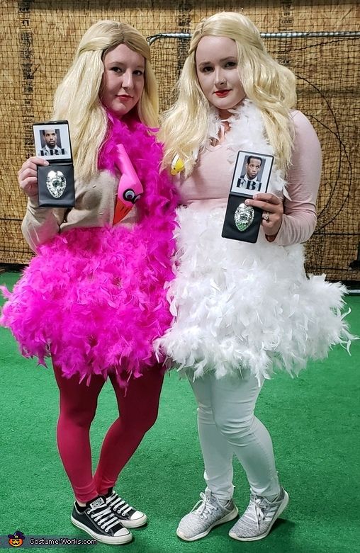 two women dressed in costumes standing next to each other on a green carpeted floor