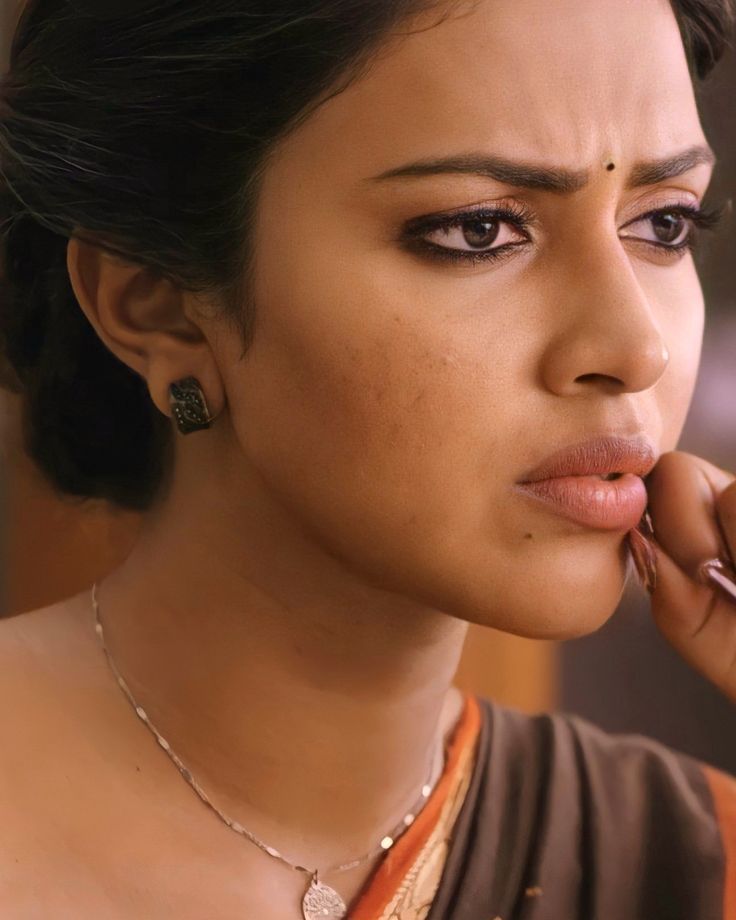 a close up of a woman talking on a cell phone with her hand to her ear