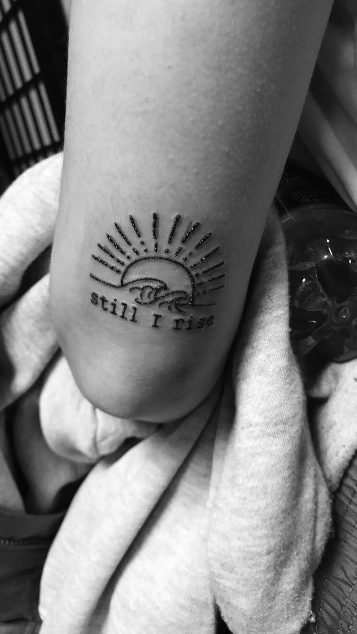 a person with a tattoo on their foot that reads still i rise, and the sun is rising