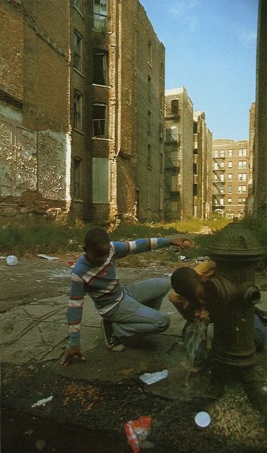 a man kneeling down next to a fire hydrant