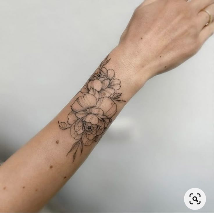 a woman's arm with a flower tattoo on it