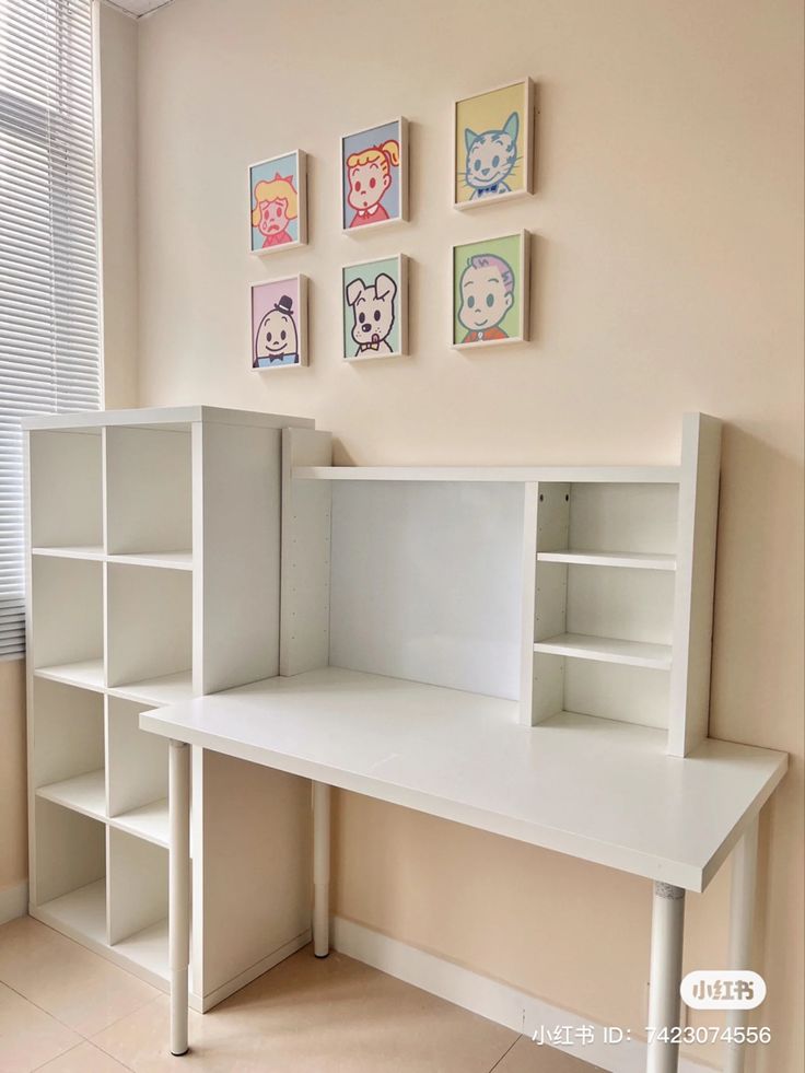 a white desk with shelves and pictures on the wall