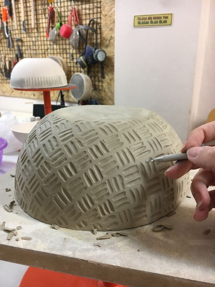 a person is working on a clay sculpture