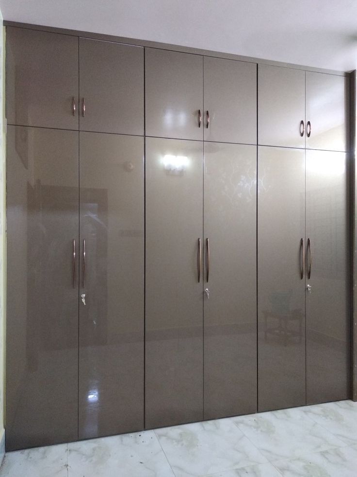 an empty room with some cabinets and marble flooring on the walls, in front of a white wall