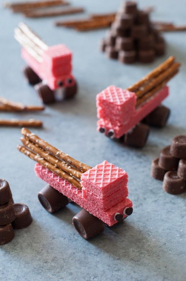 chocolate candies are arranged in the shape of train tracks and wagons with sticks sticking out of them