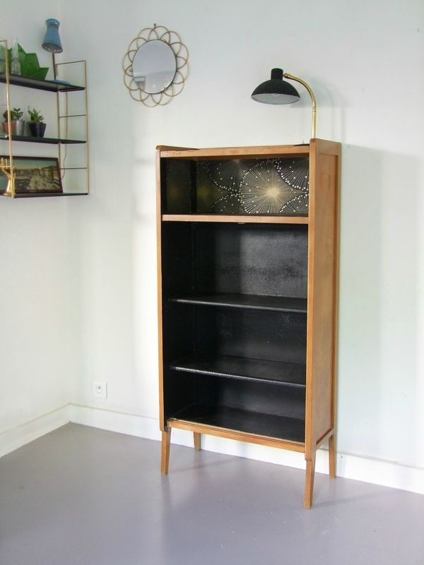 an empty room with a book shelf and lamp on the wall, next to a mirror